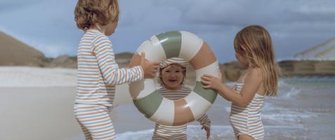 Tre barn som leker med badring